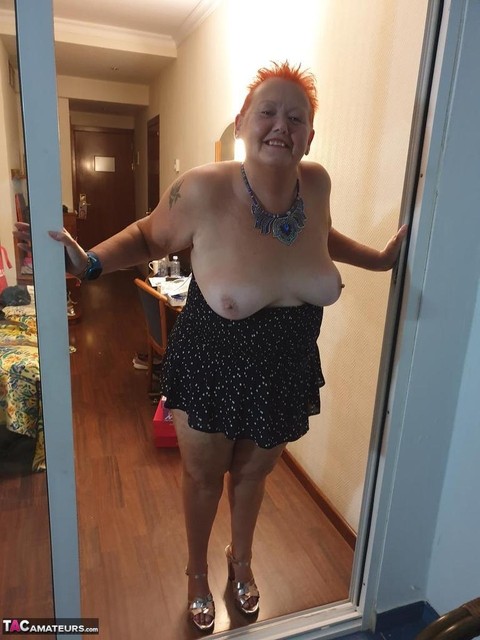 Fat nan with short red hair presses her big boobs and butt up against glass | Фото 17