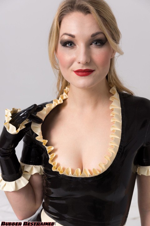 Blonde maid pauses for a drink while doing housework in latex clothing | Фото 14