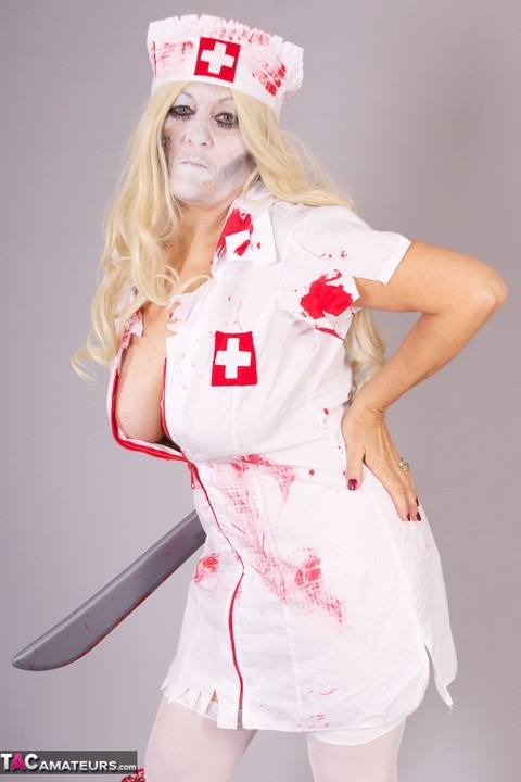 Old blonde amateur Savana removes a nurse uniform during a cosplay scene | Фото 8