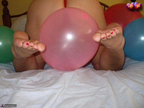 Mature woman Busty Bliss goes topless on her bed while playing with balloons | Фото 12