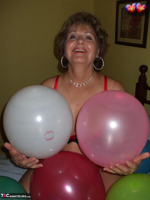 Mature woman Busty Bliss goes topless on her bed while playing with balloons | Фото 3