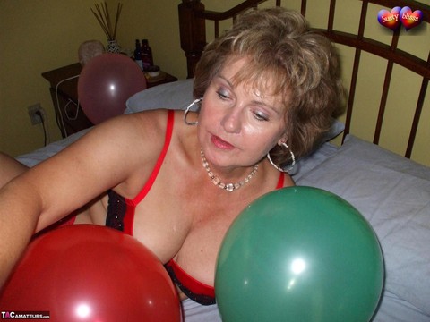 Mature woman Busty Bliss goes topless on her bed while playing with balloons | Фото 8