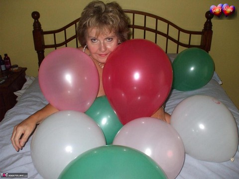 Mature woman Busty Bliss goes topless on her bed while playing with balloons | Фото 9