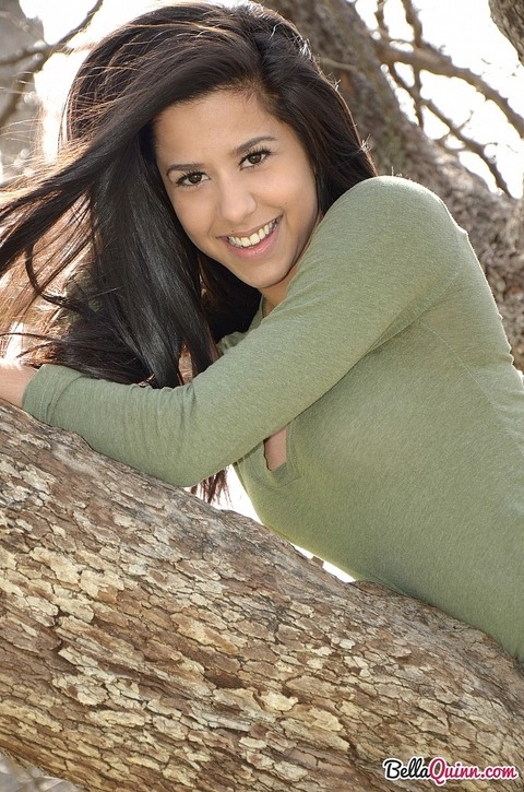 Latina chick Bella Quinn climbs a tree in the park wearing a sweater and jeans | Фото 8