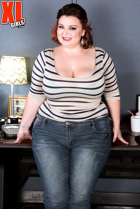 Fat chick Lucy Lenore removes denim jeans as she undresses at her work station