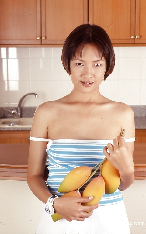 Clothed Asian with tiny tits is posing in the kitchen with spread legs | Фото 1