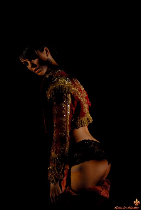 Naked dark-haired model dons bullfighting attire in the dark | Фото 13