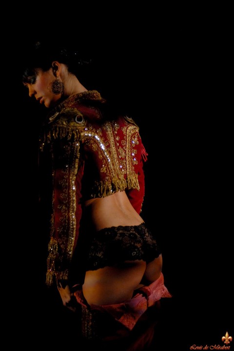 Naked dark-haired model dons bullfighting attire in the dark | Фото 14