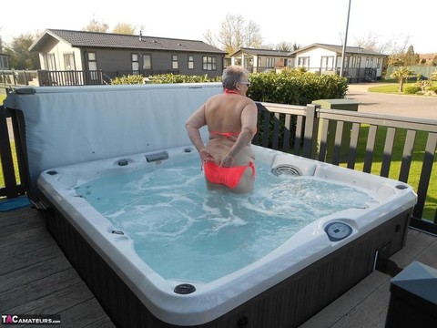 Fat nan bares her boobs while in a patio hot tub before getting naked on a bed | Фото 4