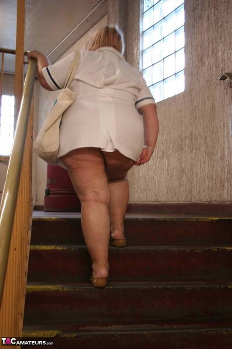 Fat older nurse Lexie Cummings exposes herself while walking on a sidewalk