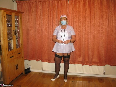 Fat nurse Chrissy Uk removes a surgical mask and uniform to model lingerie