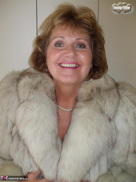 Older woman Busty Bliss licks her lips before showing her boobs in a fur coat | Фото 4