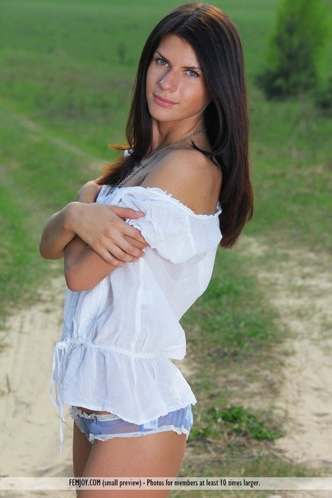 Pretty brunette Katrina gets completely naked on a dirt path in a field | Фото 1