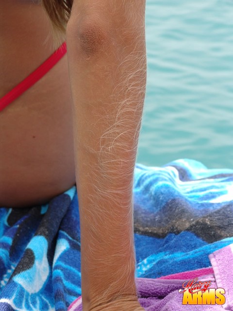 Middle-aged amateur with hairy arms models in a bikini next to the ocean | Фото 12