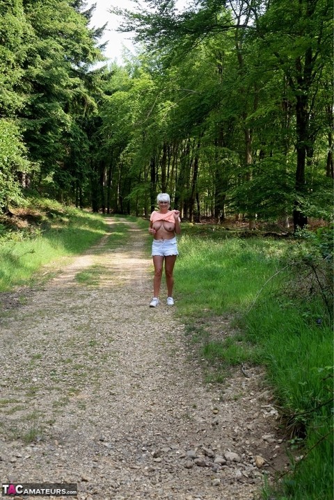 Mature amateur Dimonty stands naked in sneakers after jogging in the woods