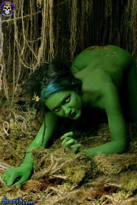 Solo girl with green skin wanders around the woods with no clothes on