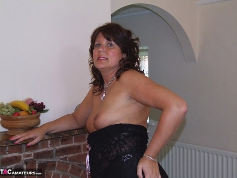 Thick mature woman Sandy looses her small tits from lingerie afore a fireplace | Фото 9