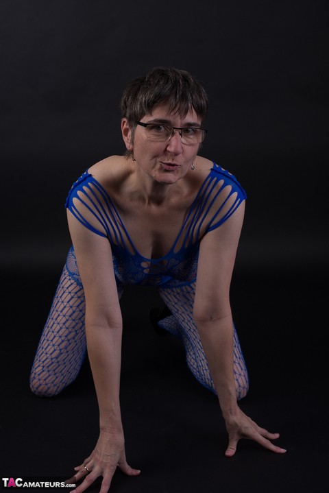 Older model poses in a crotchless bodystocking and heels with her glasses on | Фото 10