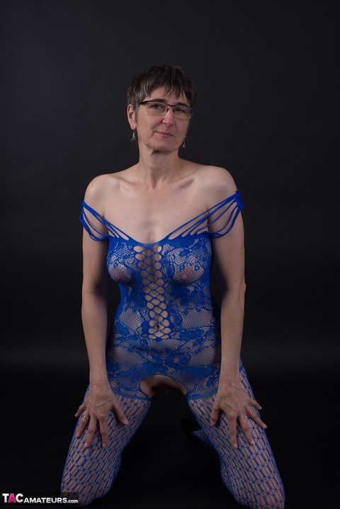 Older model poses in a crotchless bodystocking and heels with her glasses on | Фото 16