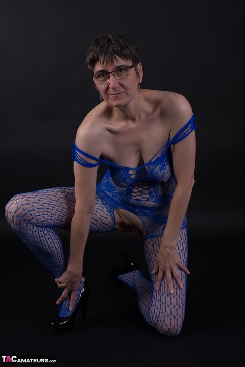 Older model poses in a crotchless bodystocking and heels with her glasses on | Фото 17