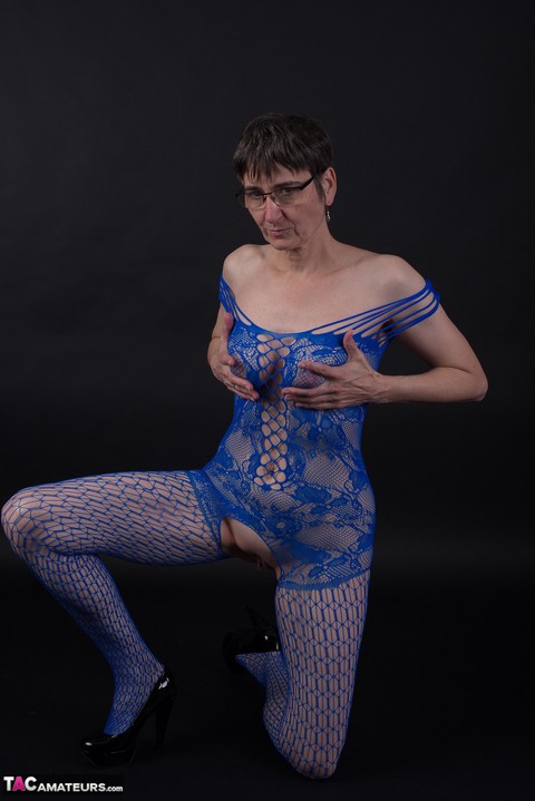 Older model poses in a crotchless bodystocking and heels with her glasses on | Фото 18