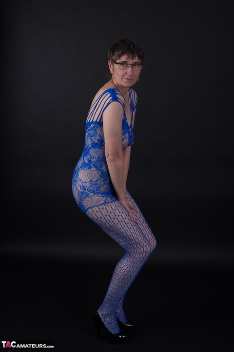 Older model poses in a crotchless bodystocking and heels with her glasses on | Фото 4