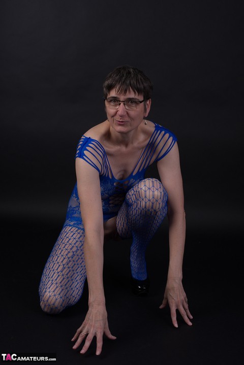 Older model poses in a crotchless bodystocking and heels with her glasses on | Фото 9