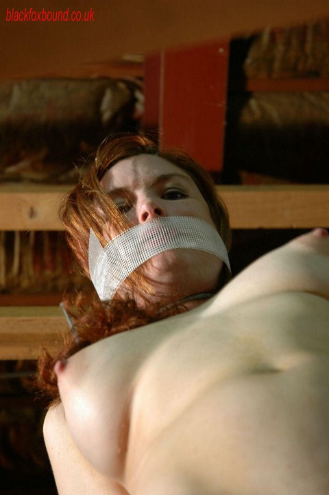 Nude redhead loses her gag while restrained with rope in a warehouse | Фото 11