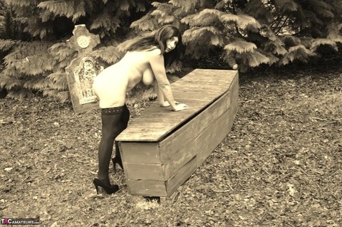 Goth girl Barby Slut bares her big tits and twat atop a casket in the woods | Фото 12