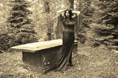 Goth girl Barby Slut bares her big tits and twat atop a casket in the woods | Фото 3