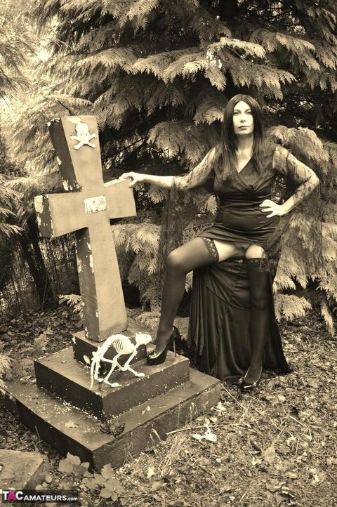 Goth girl Barby Slut bares her big tits and twat atop a casket in the woods | Фото 4