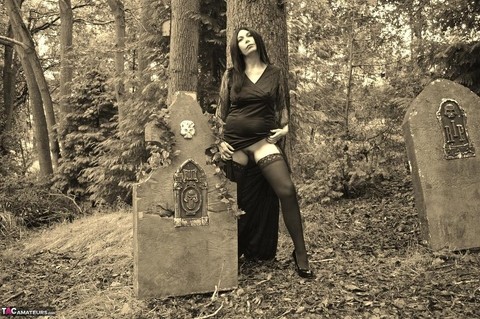 Goth girl Barby Slut bares her big tits and twat atop a casket in the woods | Фото 6