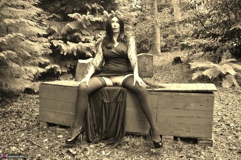 Goth girl Barby Slut bares her big tits and twat atop a casket in the woods | Фото 8