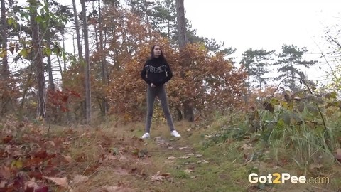 Clothed girl pulls down her pants to take a piss on a path thru the woods | Фото 14