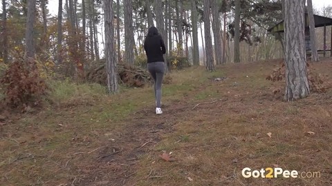 Clothed girl pulls down her pants to take a piss on a path thru the woods | Фото 15