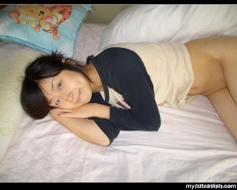 Cute Asian girl showcases her bald pussy while lying naked on her bed | Фото 11