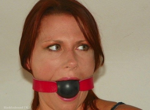 Natural redhead restrained on a bed while gagged in her clothes and heels | Фото 1