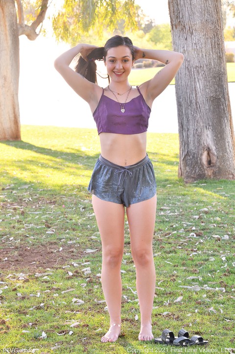 Amateur girl April does a handstand in a public park while barefoot