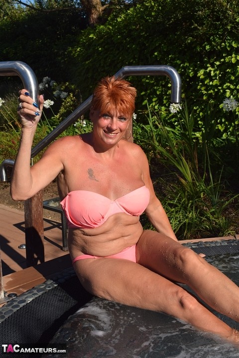 Mature redhead Dimonty shows her tits on a bench in a country field | Фото 5