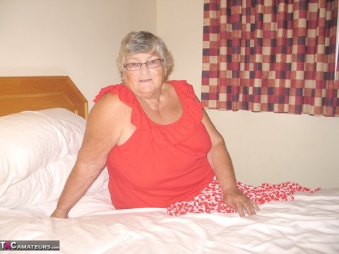 Fat British lady Grandma Libby toys her pussy on a bed in nylons and garters | Фото 1