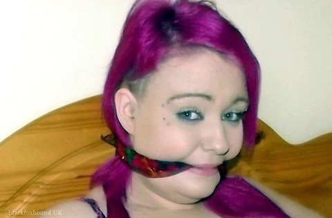 Busty girl with pink hair finds herself gagged and restrained to a chair