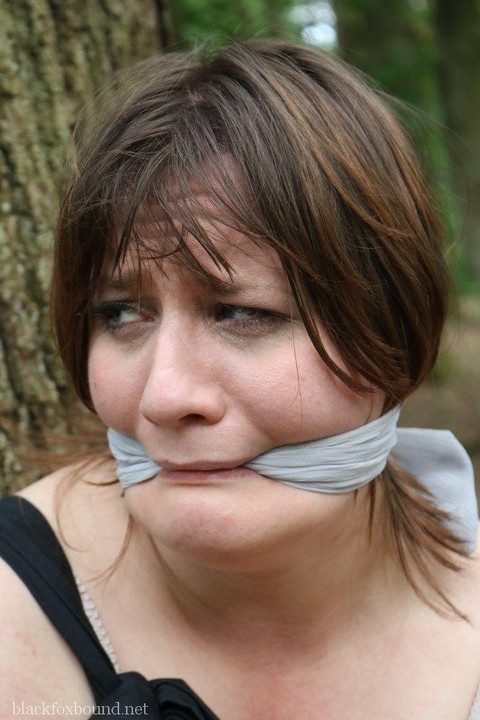 Fat female is gagged and tied to a tree in the woods with her clothes on | Фото 15