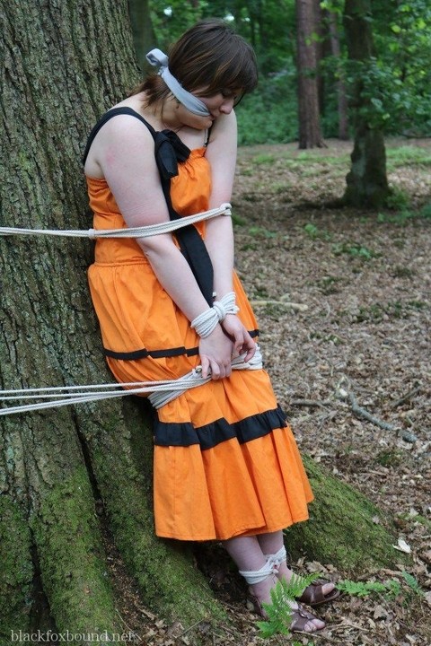 Fat female is gagged and tied to a tree in the woods with her clothes on | Фото 16