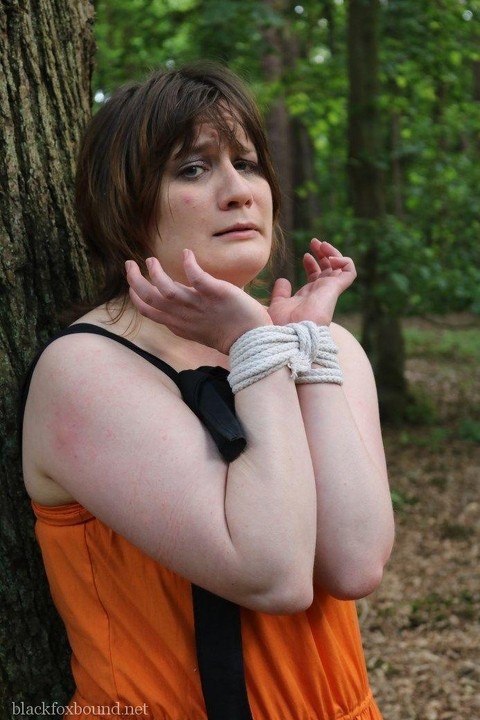 Fat female is gagged and tied to a tree in the woods with her clothes on | Фото 3