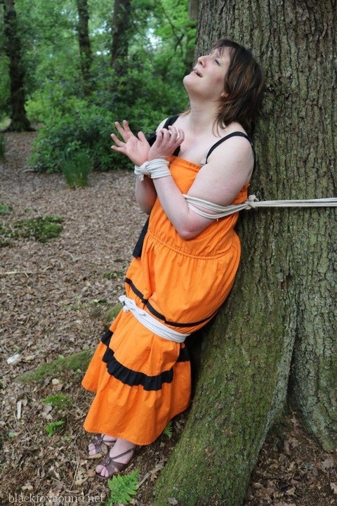 Fat female is gagged and tied to a tree in the woods with her clothes on | Фото 5