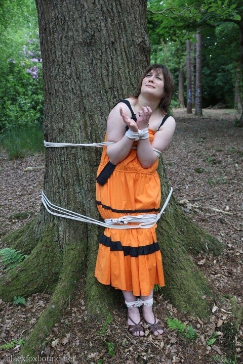 Fat female is gagged and tied to a tree in the woods with her clothes on | Фото 8