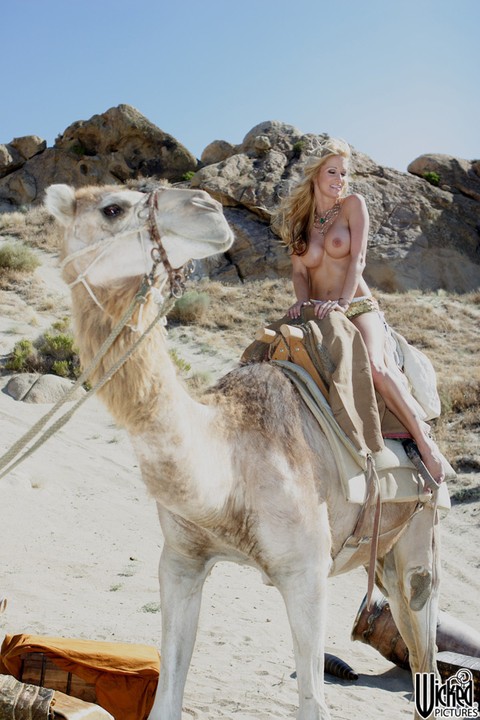 Kinky MILF Kaylani Lei flaunts her fake tits while riding a camel all nude | Фото 1