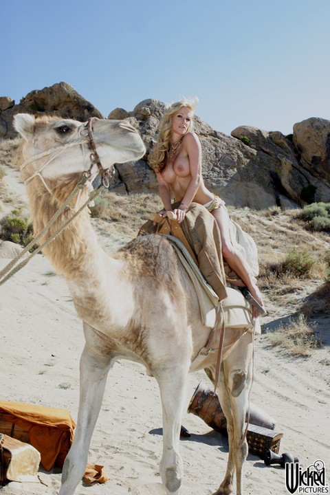 Kinky MILF Kaylani Lei flaunts her fake tits while riding a camel all nude | Фото 5