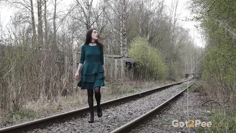 Brunette girl Lara pees on concrete blocks while walking railway tracks | Фото 1