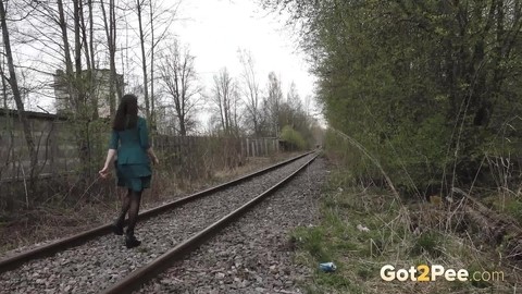 Brunette girl Lara pees on concrete blocks while walking railway tracks | Фото 15